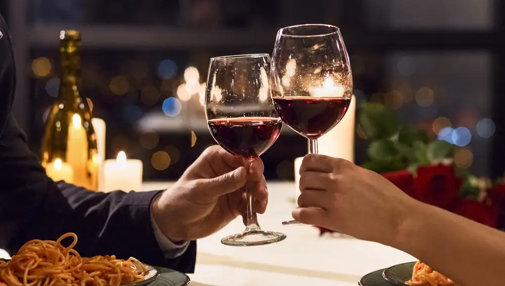 Restaurant reservation systems help restaurants manage bookings, reduce no-shows, and improve guest experiences. This image shows a two diners enjoying wine at a restaurant, with a table reserved for them through a restaurant reservation system.